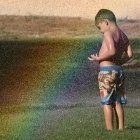 A young man enjoys a mini-rainbow.
